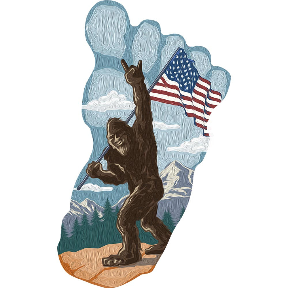 Foot-shaped sign featuring Bigfoot holding an American flag against a mountain backdrop.