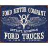 Vintage Ford Motor Company sign celebrating 100 years of Ford Trucks, featuring a winged V8 emblem and bold text.