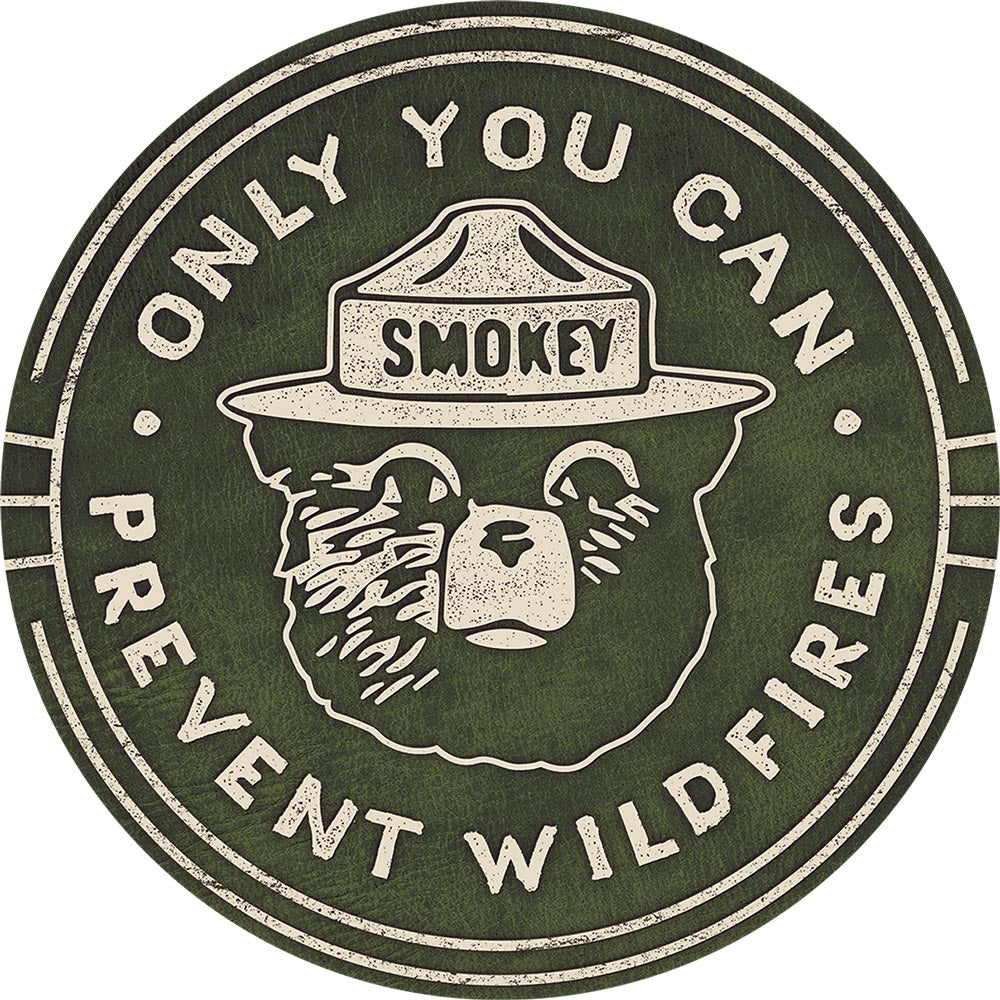 Circular sign featuring Smokey Bear with a ranger hat and the message "Only You Can Prevent Wildfires."